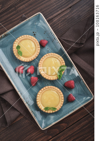 Mini tarts with lemon and custard filling Mini tarts with lemon and custard filling 108163716