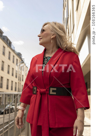 Portrait Beautiful Mature Sexagenarian Woman Standing in Street, Looking Away. Modern Building on Background. Stylish Senior Female in her 60s Wears Sunglasses. Businesswoman. Vertical Plane Portrait Beautiful Mature Sexagenarian Woman Standing in Street, Looking Away. Modern Building on Background. Stylish Senior Female in her 60s Wears Sunglasses. Businesswoman. Vertical Plane 108166365