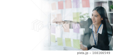 Beautiful young teen asian businesswoman using note pad thinking with planning working on financial document, tax, exchange, accounting and Financial advisor. 108166549