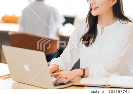 カフェでPCを見る若い女性　顔無し 108167749