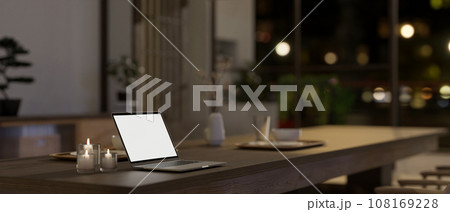 A white-screen laptop mockup on a dining table in a modern, minimal Japanese dining room style. 108169228