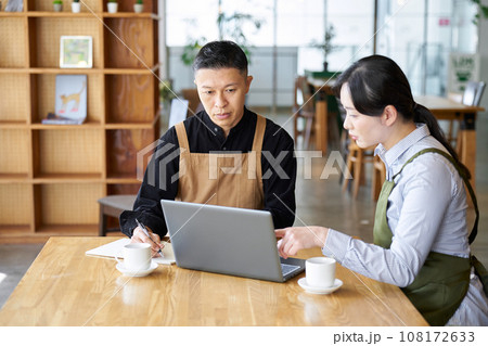 カフェの経営方針を話すアジア人夫婦 カフェの経営方針を話すアジア人夫婦 108172633