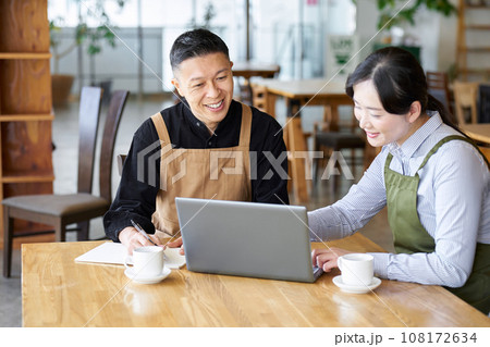 カフェの経営方針を話すアジア人夫婦 108172634