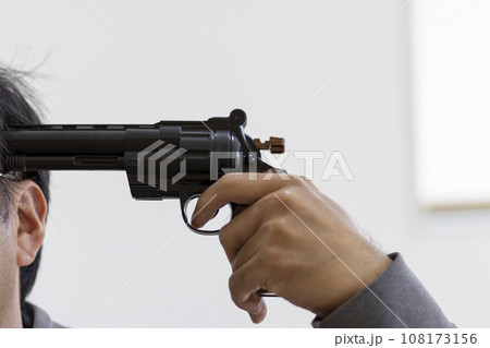 玩具の拳銃を頭に当てて自殺する男性のイメージ 108173156