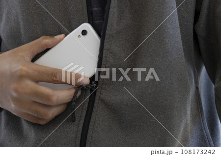 スマートフォンを持つ、顔を隠した怪しい男性  108173242