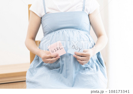 赤ちゃんの性別を示すカードを持っている妊婦女性 108173341
