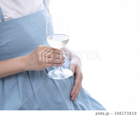 白ワインがはいったワイングラスを持った妊婦女性 108173819