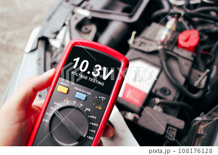 Car voltage problem is too low on black screen of digital multimeter for testing by car technician 108176128