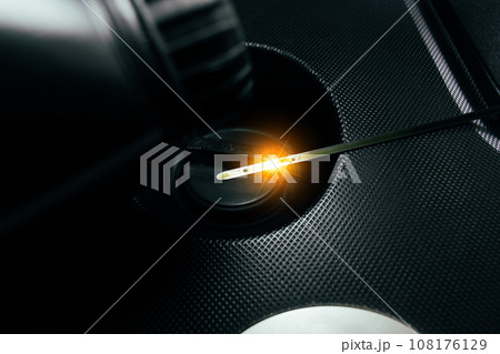 Car engine oil dipstick with reflective light on engine oil cap in a car engine compartment Car engine oil dipstick with reflective light on engine oil cap in a car engine compartment 108176129