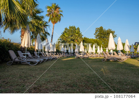 Relax on the hotel grounds or in the garden, green grass and tourist recreation. Sunbathing area with sun loungers, umbrellas, grass 108177064