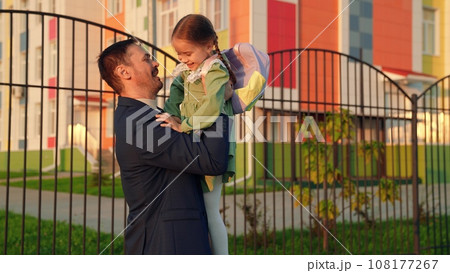 child with school backpack runs into hands his father, school lesson education, daddy care, child hugs his father, child kid daughter flight, playing superhero, happy hug flight, father day, dad child with school backpack runs into hands his father, school lesson education, daddy care, child hugs his father, child kid daughter flight, playing superhero, happy hug flight, father day, dad 108177267