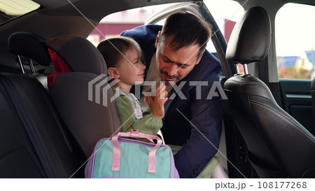 little schoolgirl sits car seat. cheerful child car. fasten your seat belt. Father unfastens child seat belt. Dad takes child out car. cheerful girl came school. learning cheerful children. happy girl little schoolgirl sits car seat. cheerful child car. fasten your seat belt. Father unfastens child seat belt. Dad takes child out car. cheerful girl came school. learning cheerful children. happy girl 108177268