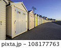 Colourful beach huts, running into the distance, set against a blue, summers sky. The location is Lyme Regis, on the south coast of England	 108177763