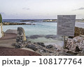 A sign of instructions on a rocky shoreline of a beach on a tropical island. 108177764