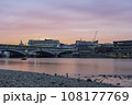 Blackfriars Bridge, London, UK, at sunset on a summer's evening. The sky is pink and orange, and it is reflecting in the River Thames 108177769