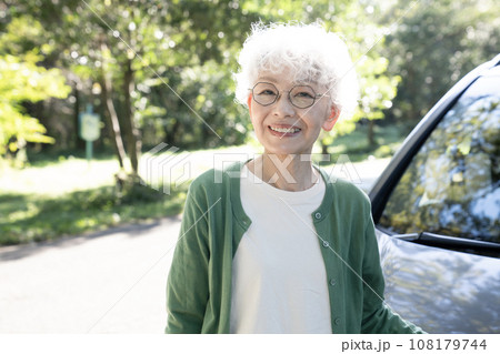車の横で微笑むシニア女性 108179744