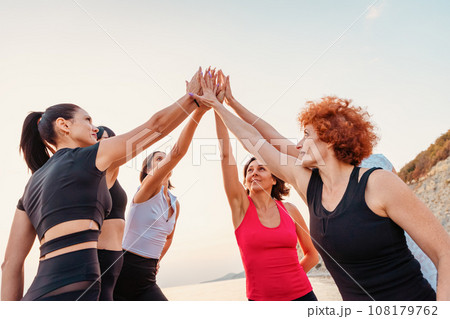 Group of Caucasian happy women wearing sportswear give five with palms. Concept of outdoor sport and team spirit Group of Caucasian happy women wearing sportswear give five with palms. Concept of outdoor sport and team spirit 108179762