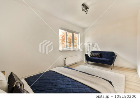 a bedroom with a bed, chair and window looking out onto the street in front of the room to the left 108180200