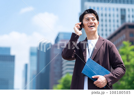 スマホを使ってオフィス街で働くミドルの男性のエンジニア 108180585