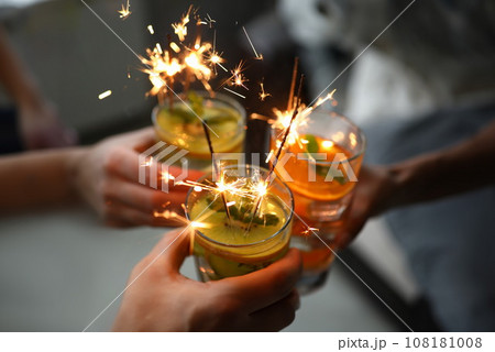 Young group friends hold in hand cocktail with sparkler 108181008