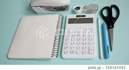 Stationery with white calculator lie on blue table epty modern Stationery with white calculator lie on blue table epty modern 108181082