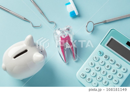 Dental tool and tooth with piggy bank and calculator on blue background, top view Dental tool and tooth with piggy bank and calculator on blue background, top view 108181149