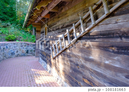 Rustic wooden stairs by the wall of the old wooden house. Latvian farm 108181663