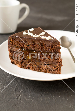 Piece of cake Sacher with apricot jam. Delicious Austrian dessert Piece of cake Sacher with apricot jam. Delicious Austrian dessert 108183343