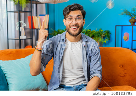 Thoughtful inspired Indian man make Eureka gesture raises finger came up creative plan at home 108183798