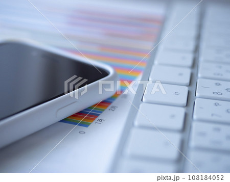 テーブルに置かれたキーボード、グラフ、スマートフォン テーブルに置かれたキーボード、グラフ、スマートフォン 108184052