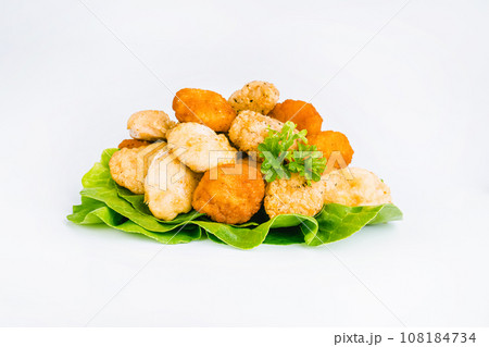 Breaded Chicken Inner Fillet with green lettuce leaves on a White Background,Chicken Breaded Raw Meat,Fillet.Breaded chicken nuggets. Fast homemade food at home.Chicken breaded schnitzels.Fast cooking 108184734