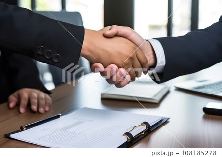 Silhouette of two influential men shaking hands in a backdrop of an office in sunset light. Silhouette of two influential men shaking hands in a backdrop of an office in sunset light. 108185278