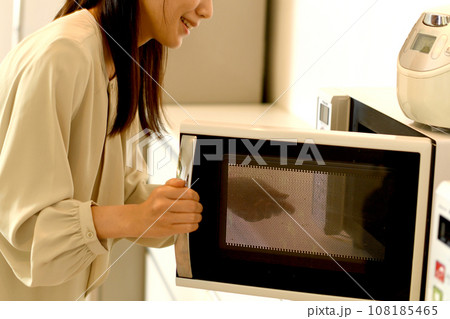 電子レンジを使う若いアジア人女性 108185465