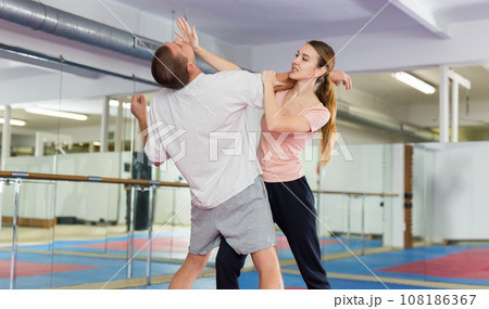 Woman learning chin strike move during self-defense training 108186367