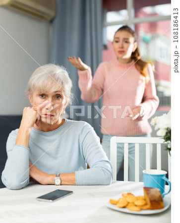 Offended elderly woman listening her daughter swearing Offended elderly woman listening her daughter swearing 108186413