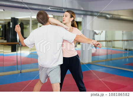 Woman learning elbow strike move during self-defense training 108186582