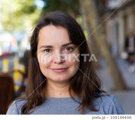 Closeup portrait of pleasant thoughtful woman on city street 108186606