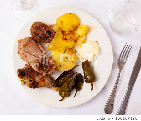 Lamb leg steaks with fried potatoes and baked padron peppers Lamb leg steaks with fried potatoes and baked padron peppers 108187128