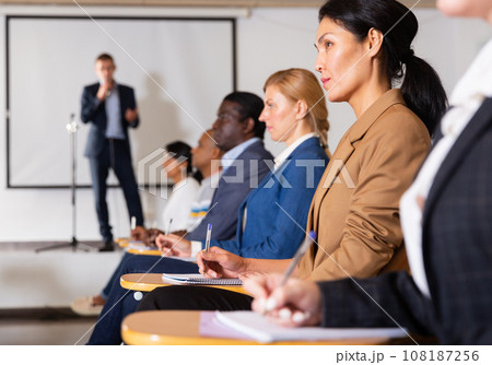 Asian businesswoman sitting at corporate seminar in conference room Asian businesswoman sitting at corporate seminar in conference room 108187256
