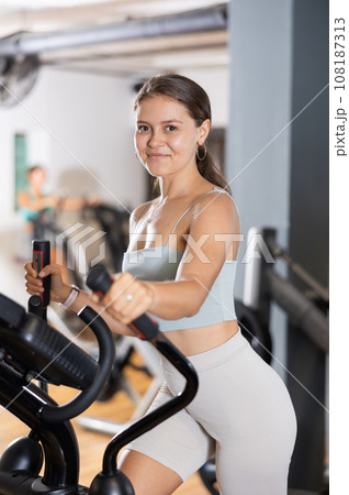 Young woman working out on elliptical machine Young woman working out on elliptical machine 108187313
