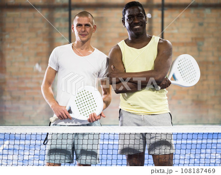 Portrait of two smiling male sportsman's posing on padel court Portrait of two smiling male sportsman's posing on padel court 108187469