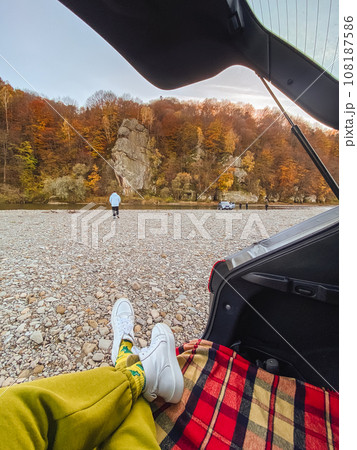 person view chilling in car trunk with autumn mountain river beach view 108187586