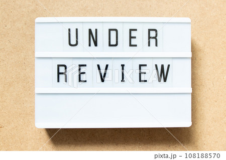 Lightbox with word under review on wood background 108188570