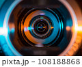 Video camera lens lit by blue and orange color light 108188868