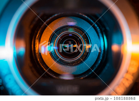 Video camera lens lit by blue and orange color light 108188868
