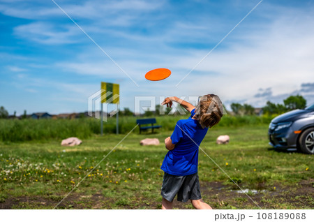 Caucasian child playing disc golf and making the first toss 108189088