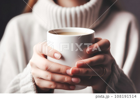 Closeup of female in a warm sweater holding in hands white mug of beverage. Generative AI.	 108191514