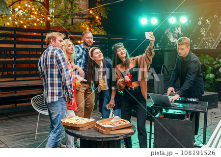 Pretty young women and handsome guys at celebration party making selfie photo on smartphone. Pretty young women and handsome guys at celebration party making selfie photo on smartphone. 108191526