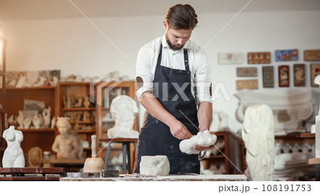 Bearded sculptor measures stone woman torso to make copy of it from limestone at creative studio. Bearded sculptor measures stone woman torso to make copy of it from limestone at creative studio. 108191753