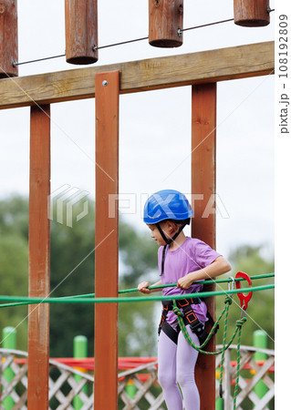 Child on ropes course with helmet and harness 108192809